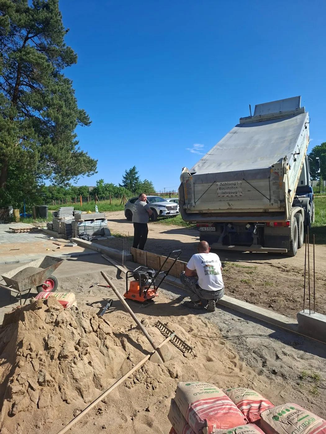 Prace ziemne, obrzeża i materiały przygotowane do kolejnych etapów.