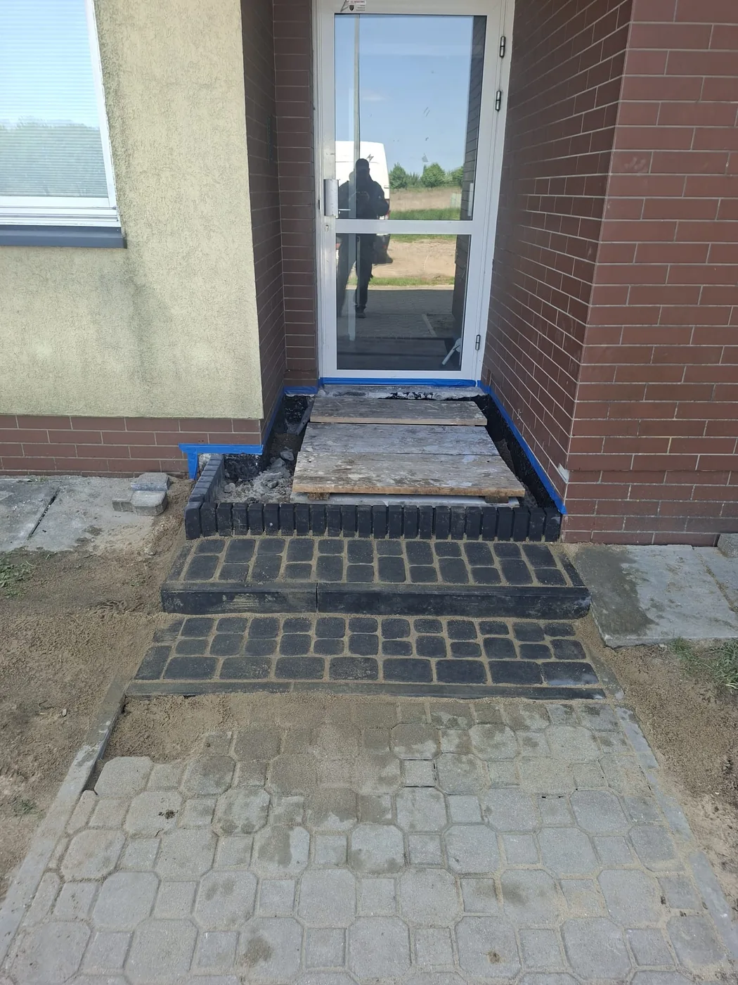Gotowe stopnie z ciemnej kostki dopasowane do elewacji.